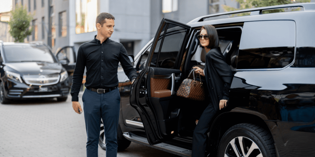 A man and woman entering a black SUV parked on a street.